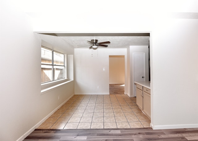 unfurnished room featuring ceiling fan, a textured ceiling, and light hardwood / wood-style flooring