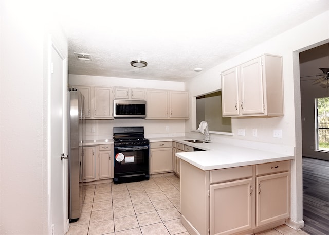 kitchen with sink, ceiling fan, light tile patterned floors, appliances with stainless steel finishes, and kitchen peninsula