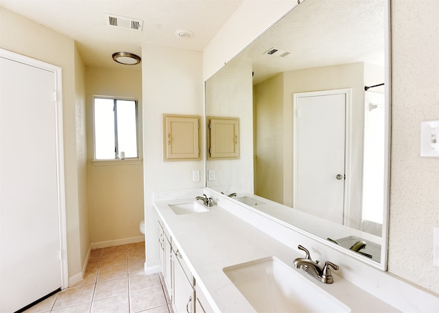 bathroom with tile patterned flooring, vanity, and toilet