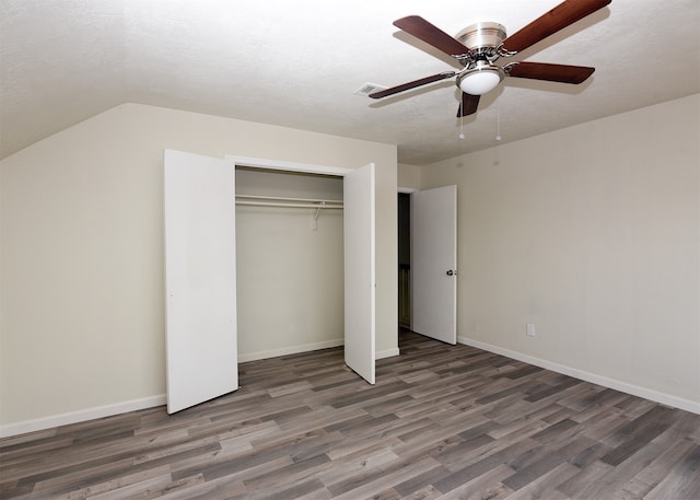 unfurnished bedroom featuring a textured ceiling, ceiling fan, dark wood-type flooring, a closet, and lofted ceiling