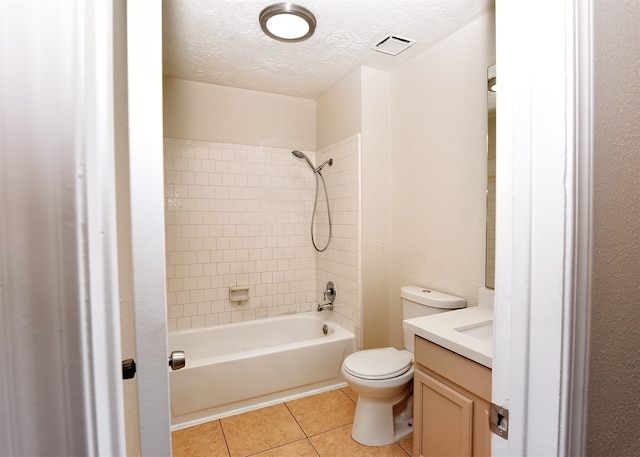 full bathroom featuring vanity, tile patterned flooring, tiled shower / bath combo, toilet, and a textured ceiling