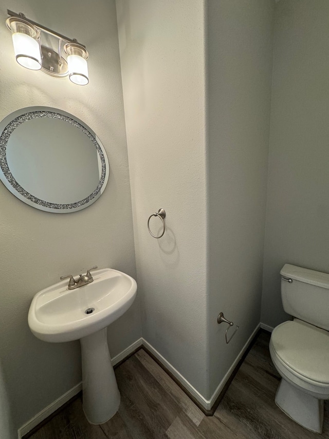 bathroom with hardwood / wood-style floors and toilet