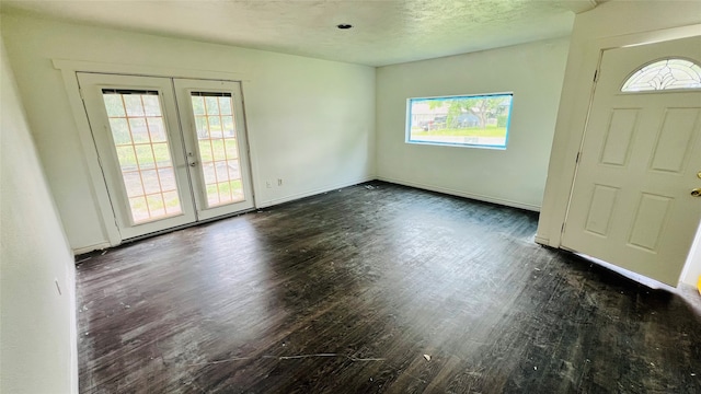 foyer entrance featuring french doors, a textured ceiling, and dark hardwood / wood-style floors