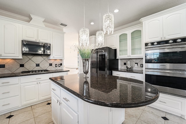 kitchen featuring appliances with stainless steel finishes, tasteful backsplash, a kitchen island, and ornamental molding