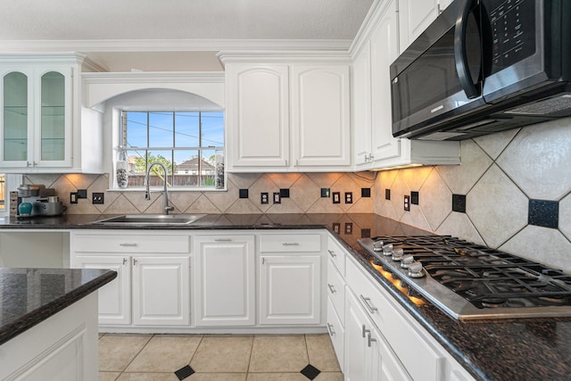 kitchen with appliances with stainless steel finishes, backsplash, white cabinetry, and sink