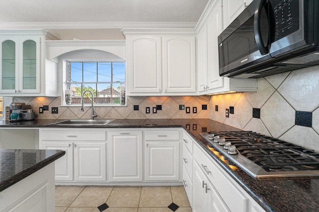 8215 Arrowhead Ln, Houston, TX 77075 - kitchen featuring stainless steel gas cooktop, a sink, white cabinetry, crown molding, and light tile patterned flooring