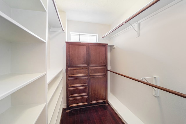 spacious closet with dark wood-type flooring