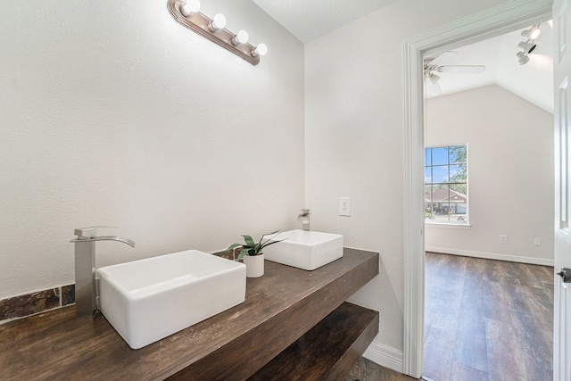 bathroom with hardwood / wood-style floors, ceiling fan, sink, and vaulted ceiling