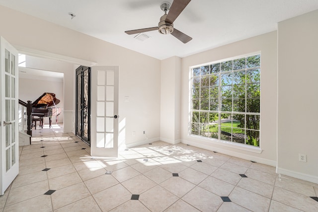 tiled spare room featuring french doors and ceiling fan