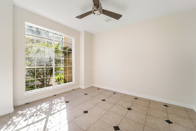 spare room with ceiling fan and light tile patterned flooring