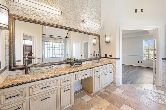 bathroom featuring hardwood / wood-style flooring, vanity, and a towering ceiling