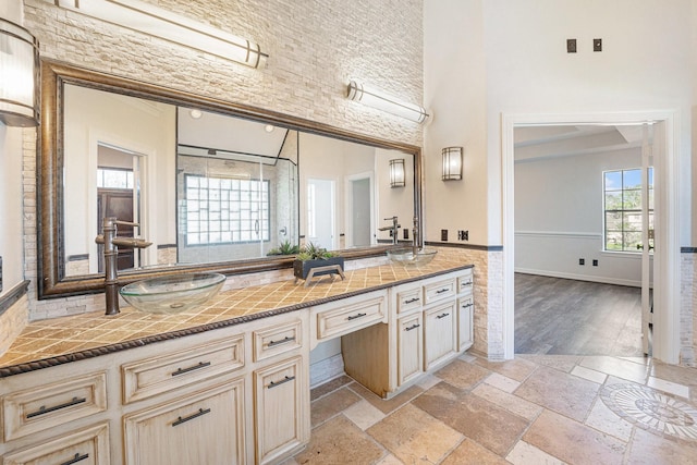 8215 Arrowhead Ln, Houston, TX 77075 - bathroom with double vanity, a high ceiling, stone tile floors, and a shower