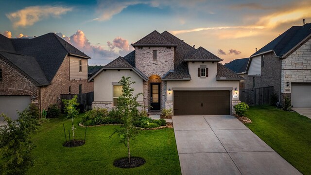 view of front of house with a garage and a yard