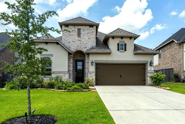 view of front of home with a front yard and a garage