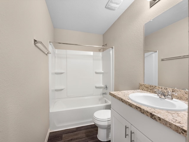 full bathroom featuring hardwood / wood-style floors, a textured ceiling, toilet, shower / tub combination, and vanity