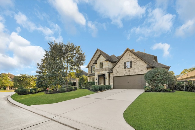 french provincial home featuring a front yard and a garage