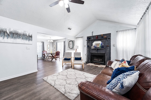 living room featuring a textured ceiling, dark hardwood / wood-style flooring, ceiling fan with notable chandelier, and lofted ceiling