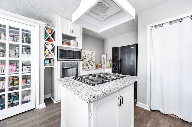 kitchen featuring white cabinets, dark hardwood / wood-style floors, a center island, and stainless steel appliances