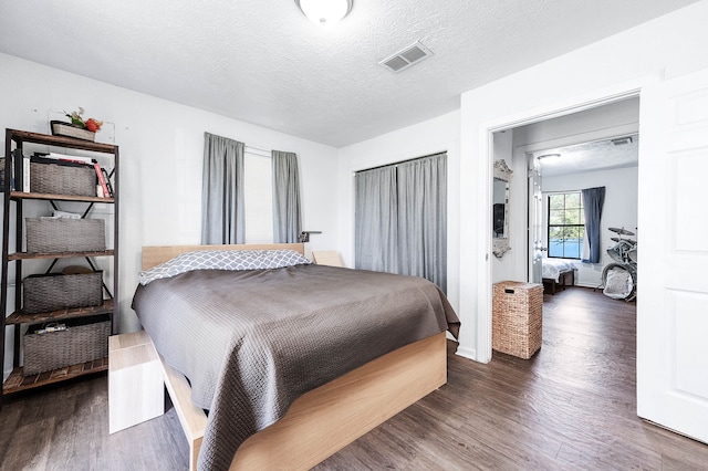 bedroom featuring a textured ceiling and dark wood-type flooring