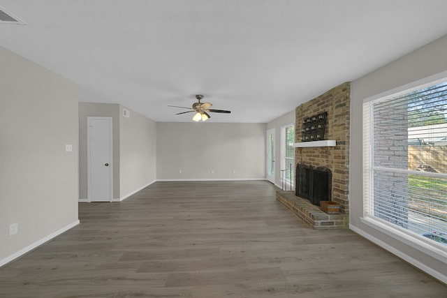 unfurnished living room featuring dark wood-type flooring, a fireplace, and ceiling fan