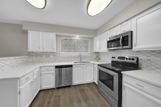 kitchen with sink, appliances with stainless steel finishes, dark hardwood / wood-style floors, decorative backsplash, and white cabinets