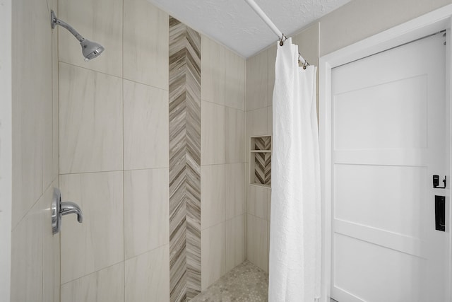 bathroom with a textured ceiling and a shower with shower curtain