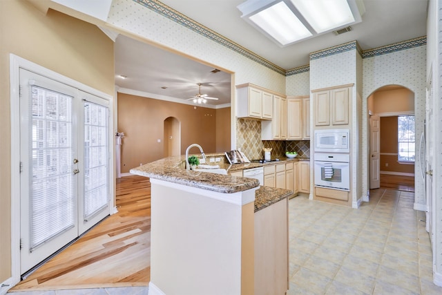 kitchen featuring stone counters, sink, cream cabinets, white appliances, and ornamental molding