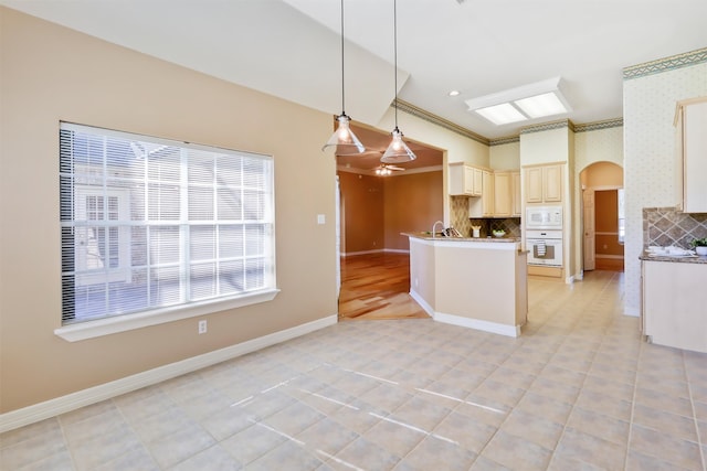 kitchen with cream cabinetry, backsplash, crown molding, white appliances, and decorative light fixtures