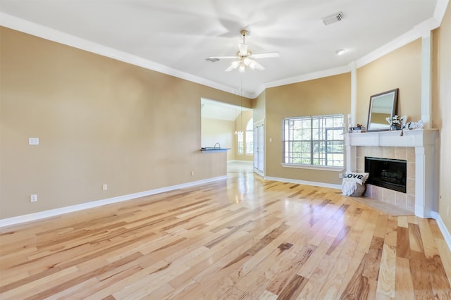 unfurnished living room with a fireplace, light hardwood / wood-style flooring, ceiling fan, and ornamental molding