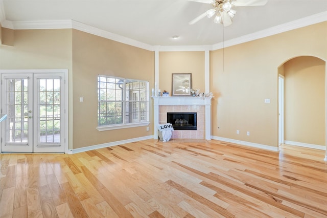 unfurnished living room with a tile fireplace, light hardwood / wood-style floors, ceiling fan, and crown molding