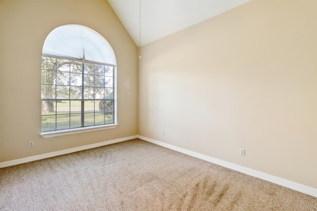 spare room with carpet floors and vaulted ceiling