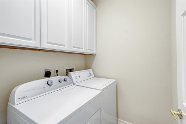 washroom with cabinets and washing machine and dryer