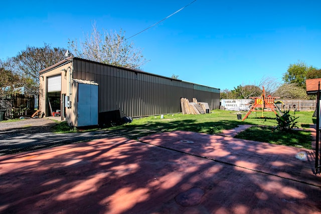 view of outdoor structure with a playground and a yard