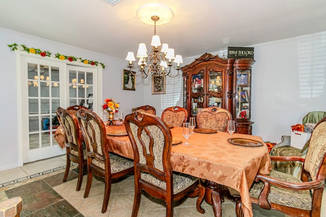 dining space featuring french doors, a chandelier, and ornamental molding