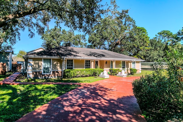 ranch-style house featuring covered porch and a front yard