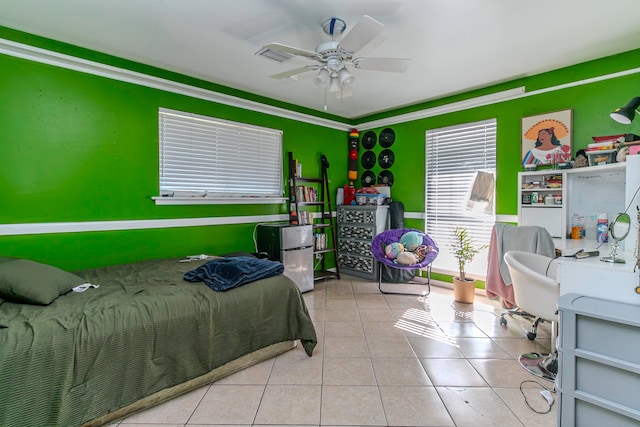 tiled bedroom with ceiling fan and ornamental molding