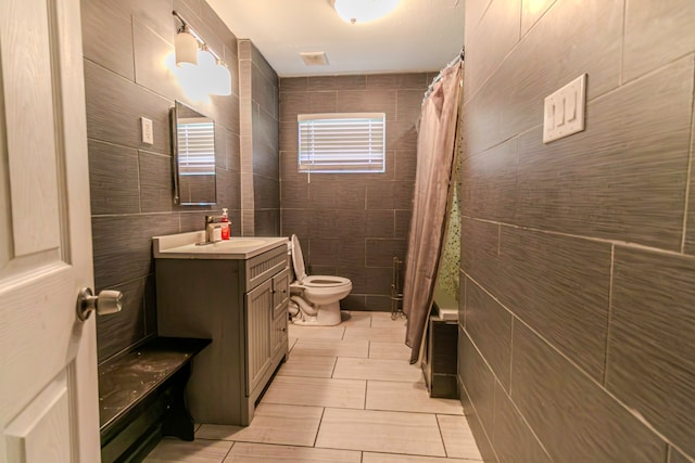 bathroom featuring curtained shower, vanity, tile walls, and toilet