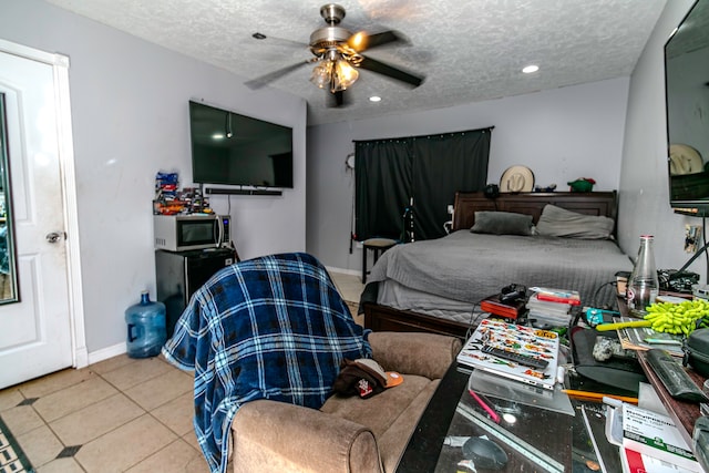 bedroom featuring ceiling fan, light tile patterned flooring, and a textured ceiling