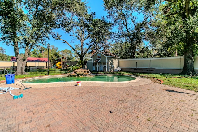 view of swimming pool featuring a playground and a patio area