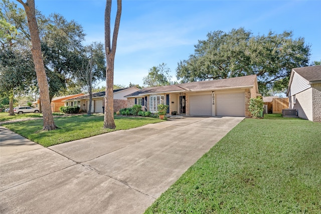 ranch-style home featuring a garage, a front yard, and central AC unit