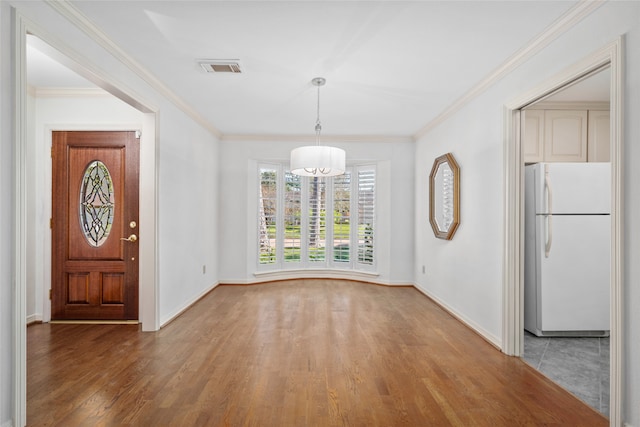 unfurnished dining area with dark wood-type flooring and crown molding