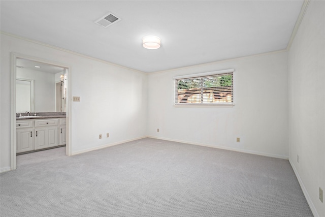 carpeted empty room featuring sink and crown molding