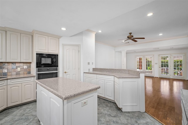 kitchen with ceiling fan, a center island, decorative backsplash, stainless steel oven, and black microwave