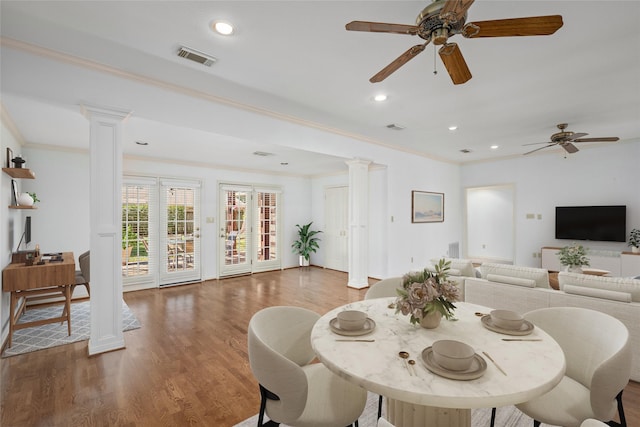 dining area featuring ceiling fan, dark hardwood / wood-style flooring, crown molding, and decorative columns