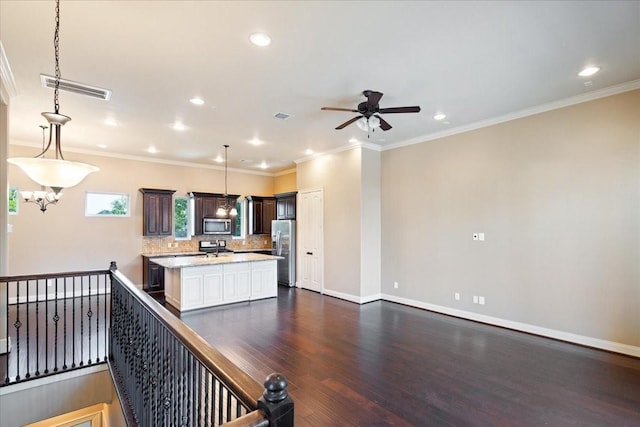 1516 Amundsen St, Houston, TX 77009 - kitchen with appliances with stainless steel finishes, a ceiling fan, recessed lighting, decorative backsplash, and a kitchen island