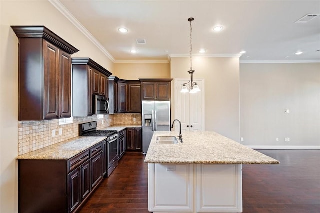 1516 Amundsen St, Houston, TX 77009 - kitchen with stainless steel appliances, dark brown cabinets, a center island with sink, a chandelier, and backsplash