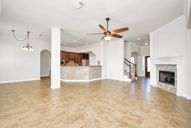 unfurnished living room with ceiling fan and crown molding