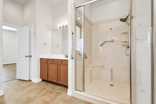 bathroom featuring tile patterned flooring, an enclosed shower, and vanity