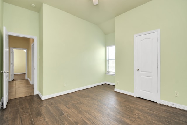 spare room with dark hardwood / wood-style flooring, ceiling fan, and vaulted ceiling