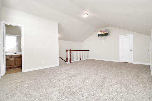 additional living space with vaulted ceiling and light colored carpet